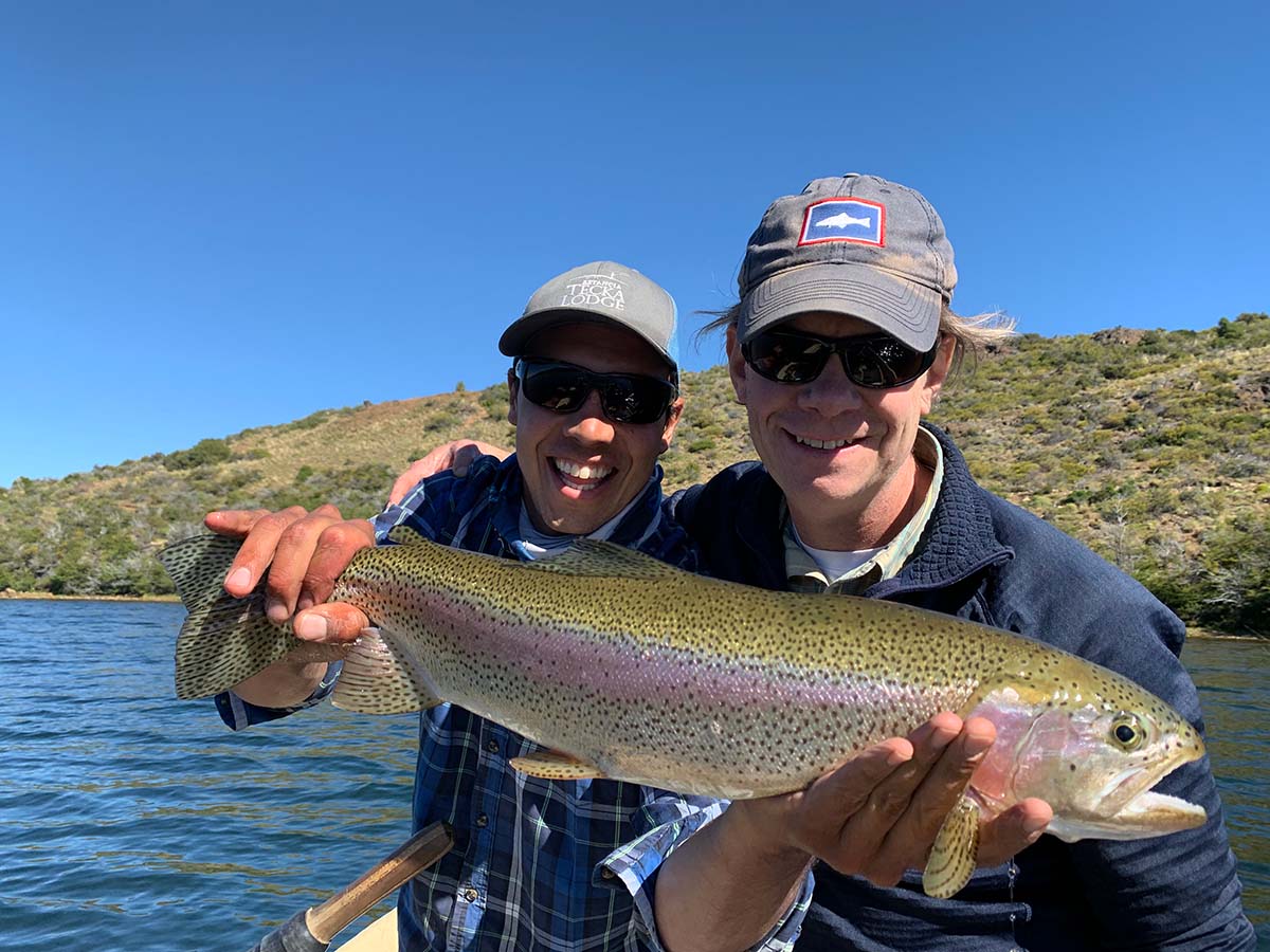 Two smiling men holding a nice rainbow trout