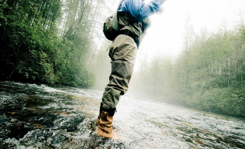 man standing in a river fly fishing